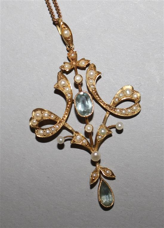 An Edwardian 15ct gold, aquamarine and seed pearl set pendant, on a 9ct gold fine link chain.